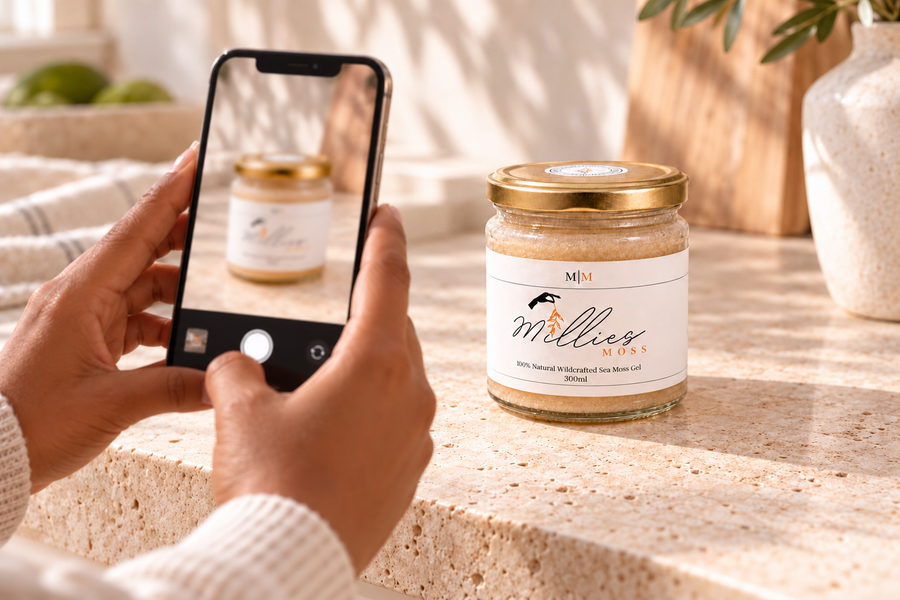 A customer photographing a closed Millie’s Moss Golden Gel jar with a smartphone.