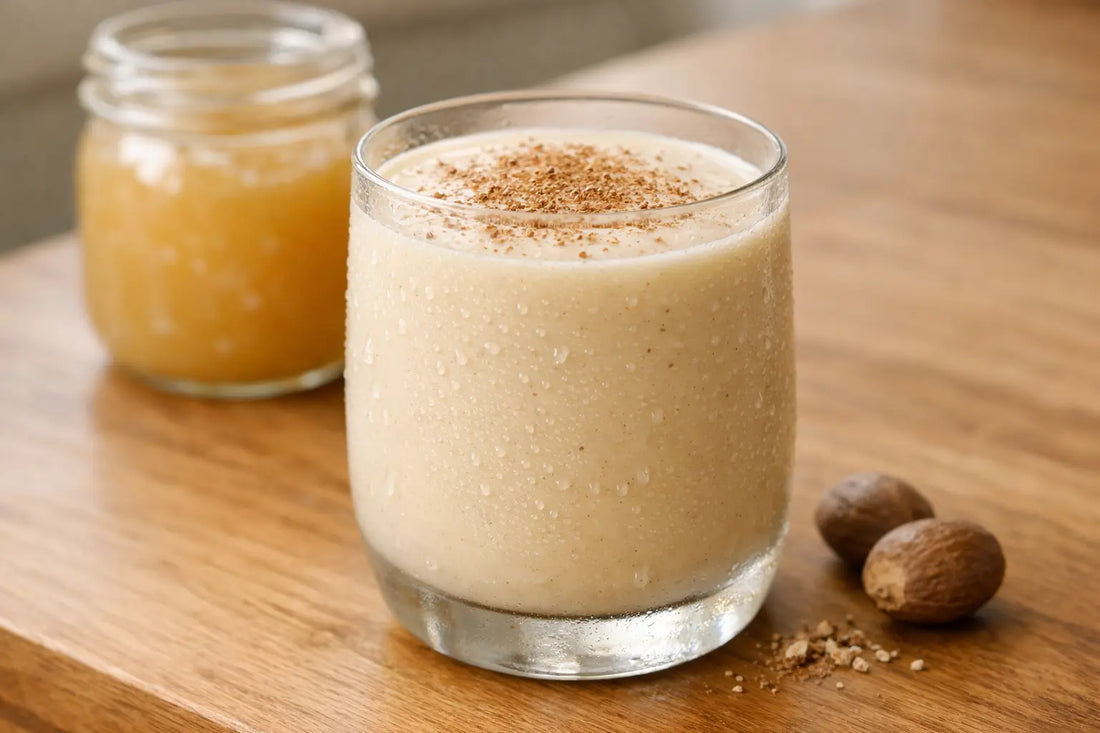 Creamy banana Irish moss drink topped with nutmeg beside a jar of sea moss gel
