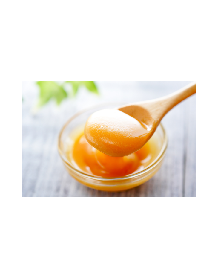 Spoonful of manuka honey substance in a glass bowl on a white background