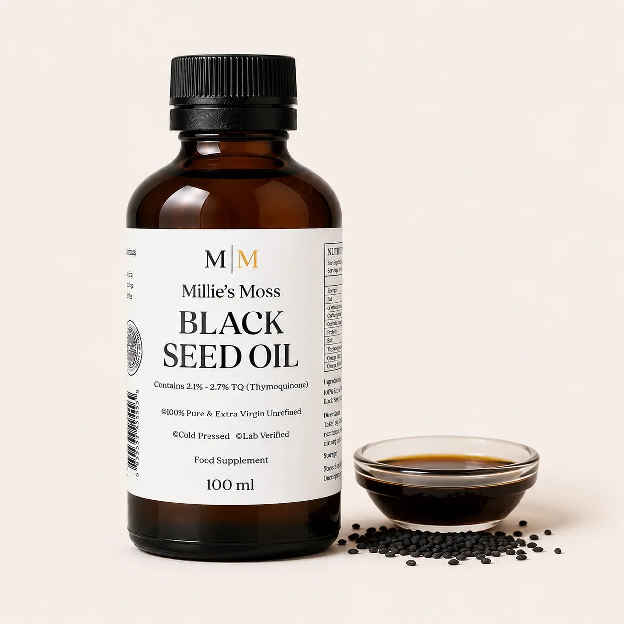 Millie's Moss High Strength Black Seed Oil 100ml bottle beside a glass dish of black seed oil with whole black seeds on an off-white background.