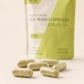 Close-up of Millie’s Moss Sea Moss with Aloe Vera Capsules showing pale green capsules in front of the product pouch.