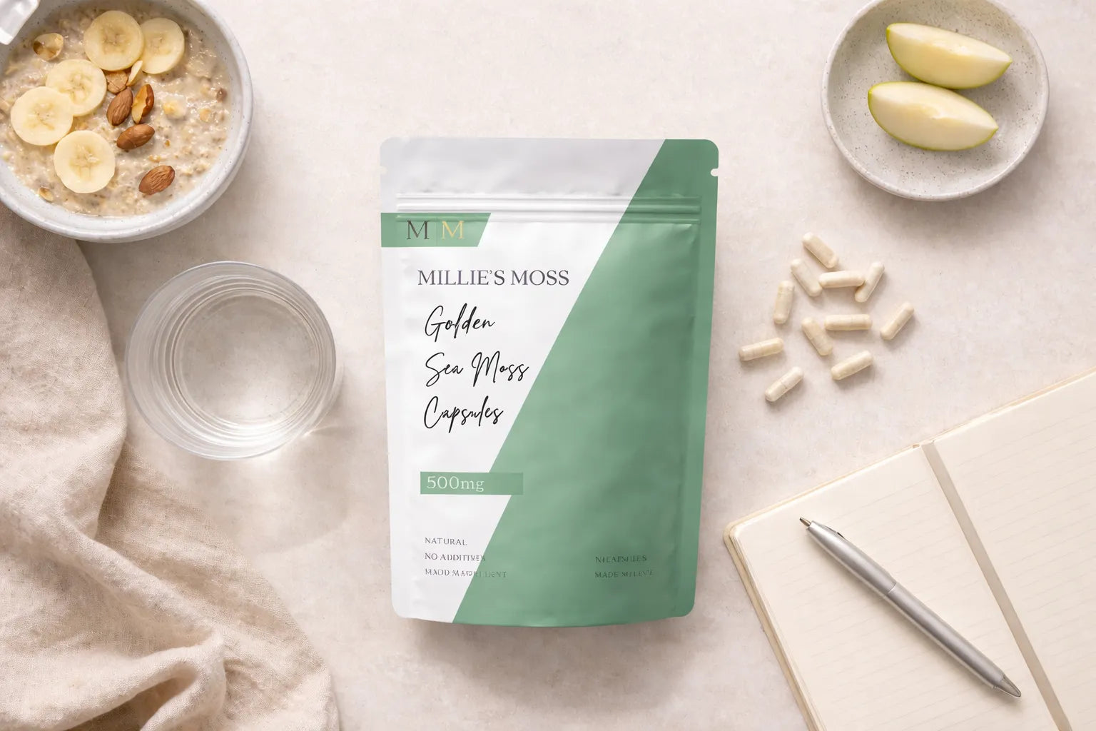 Flat lay of sea moss capsules with breakfast bowl, apple slices, and notebook for a daily wellness routine.