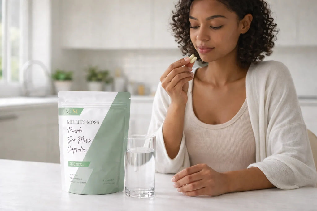 Woman taking purple sea moss capsules with water as part of a healthy daily supplement routine.